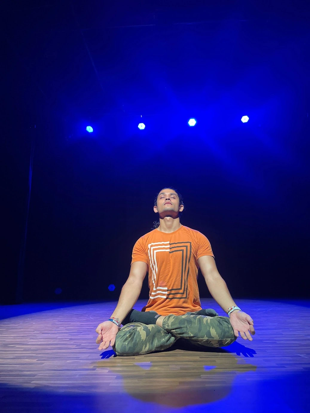 I sit cross-legged on stage, eyes closed and palms open