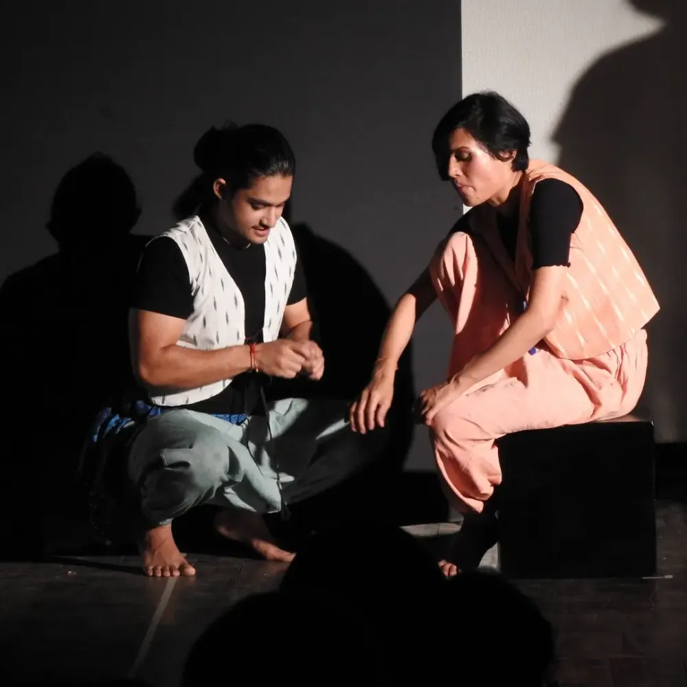 I sit with a fellow performer in Beyond the Land of Hattamala