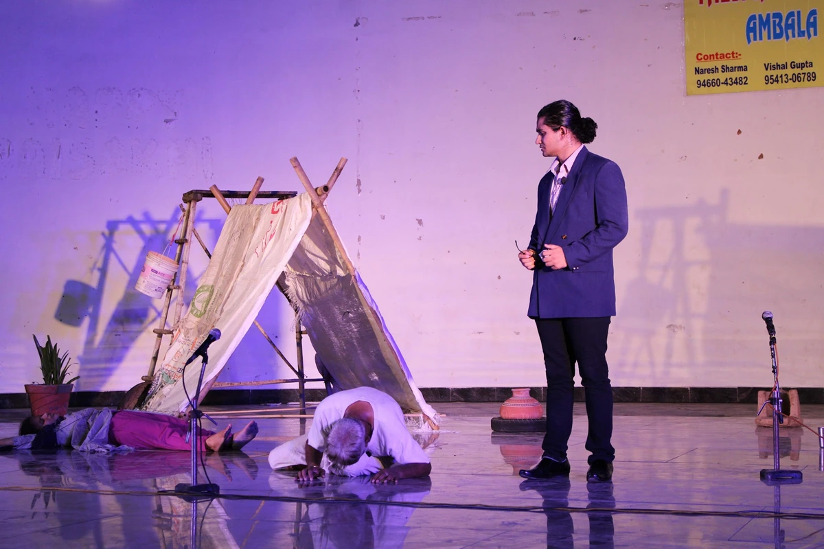 I stand in a blue jacket beside a performer bent to the floor