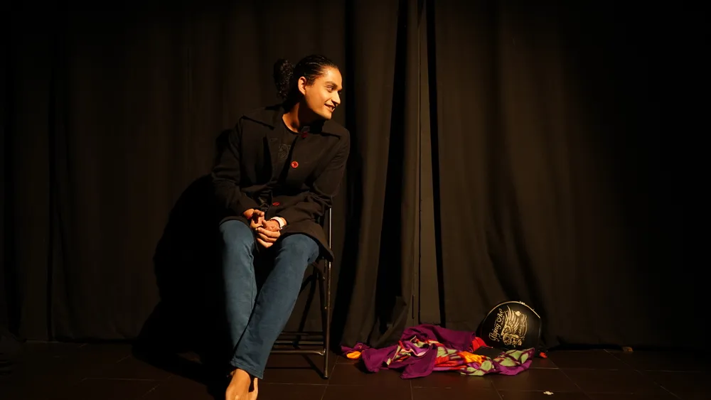 I sit beside a colourful cloth on stage